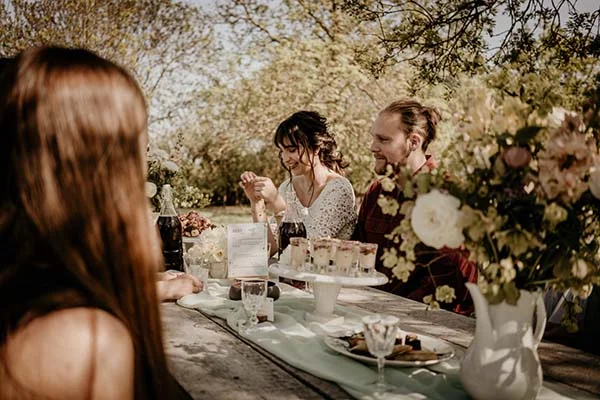 Magique repas en plein air avec des desserts élégants et des fleurs naturelles, inspirant un mariage écologique et sauvage.