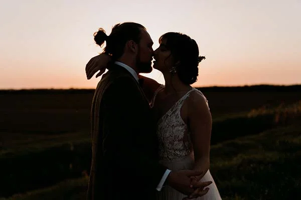 Couple romantique au coucher de soleil, idéal pour un mariage naturel et éco-responsable.