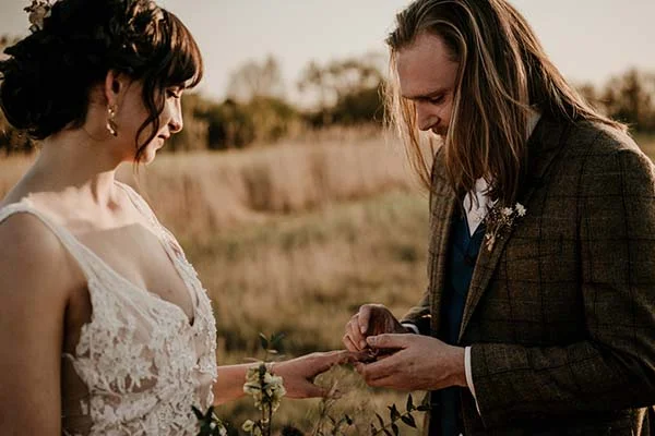 Un couple en amour profond se marient dans une belle cérémonie en plein air, avec des détails floraux naturels et un