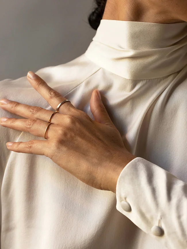 Élegance et discrétion incarnées dans un manteau blanc et un ensemble de bijoux minimaliste.