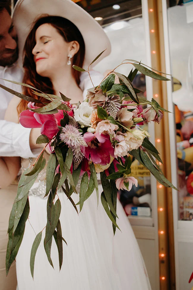 Un couple dans un shooting romantique à Las Vegas, l'homme tenant doucement la femme qui porte un bouquet de fleurs