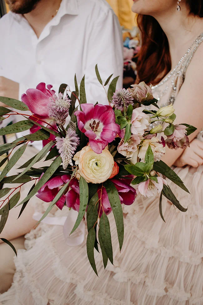 Un bouquet coloré de fleurs fraîches, symbolisant l'harmonie et l'émotion, partagé par deux personnes en larmes de