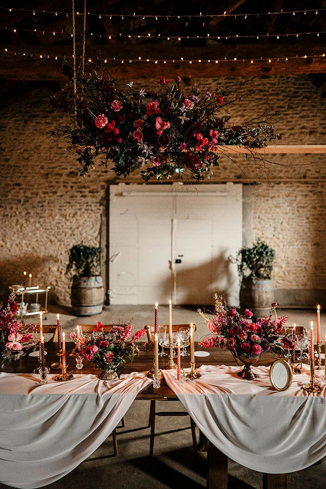 Évocation romantique d'un mariage vintage avec une combinaison chaude de magenta et de rouge, décoré avec des fleurs