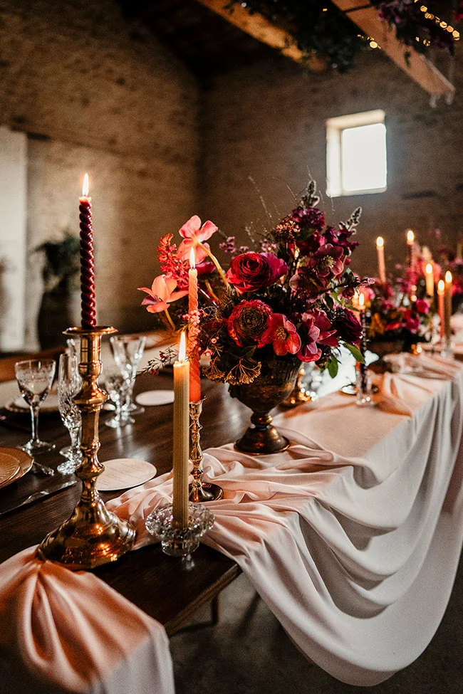 Tableau de banquet magnifique avec des bougies brûlantes et des fleurs magenta, créant un atmosphère romantique et