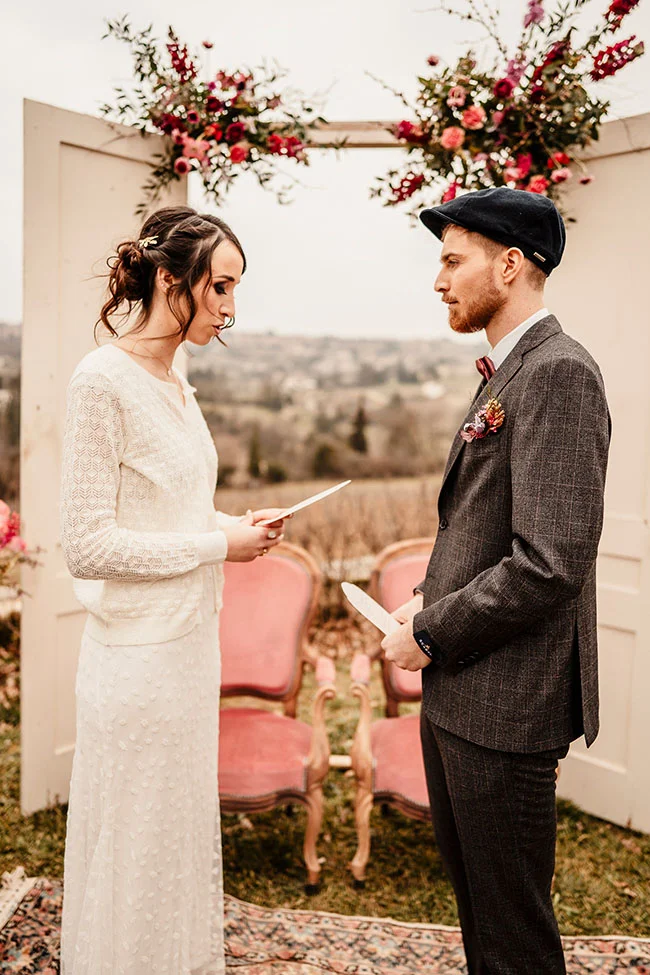Un couple de mariés en harmonie avec des détails romantiques vintage et un toucher de magenta doux.