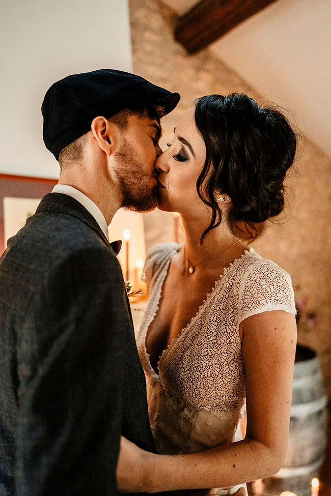 Un couple romantique partage un baiser tendre dans un décor vintage, avec une atmosphère chaude et intime.