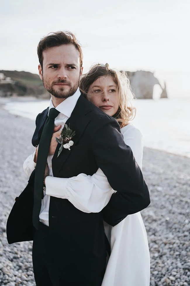 Un couple romantique en cérémonie de mariage à Etretat, avec un fond époustouflant de falaises roches.