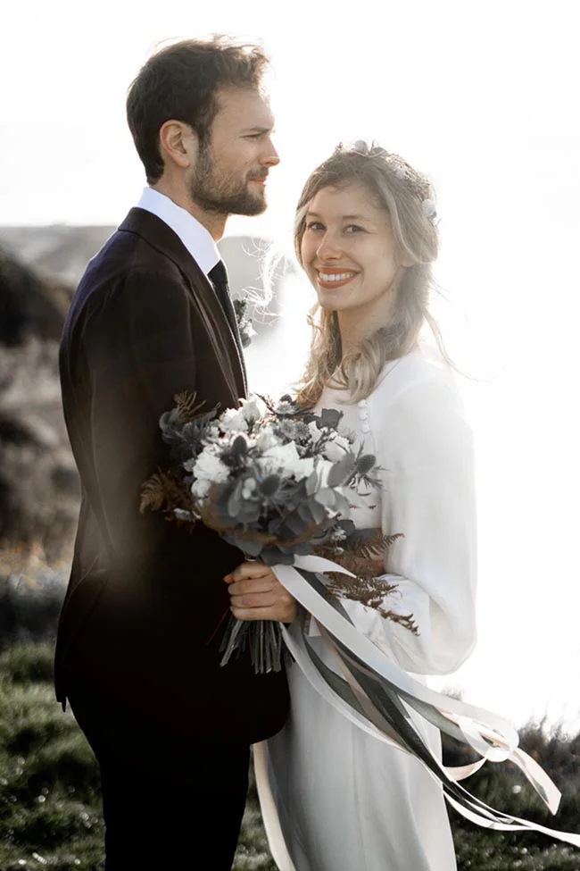 Un couple heureux dans des costumes élégants contre un décor naturel à l'île de France.