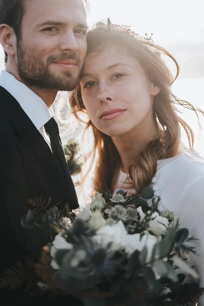 Un couple charmant à l'Étretat, célébrant leur mariage en petit comité avec des fleurs élégantes.