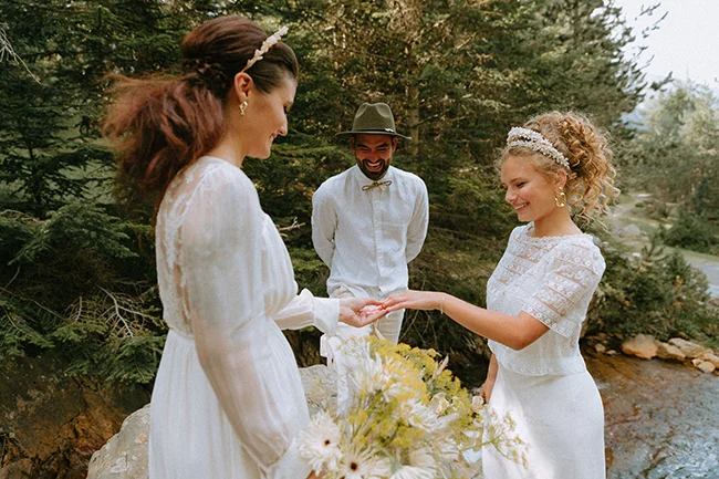 Magique mariage dans les Pyrénées, avec des robes blanches et des fleurs fraîches, un couple se marient en plein air.