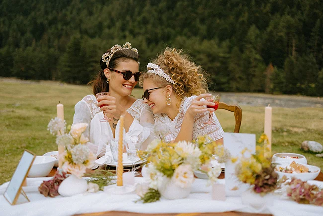 Célébration romantique dans les Pyrénées, avec deux mariées en blouse blanche et ornements en fleurs, célébrant leur