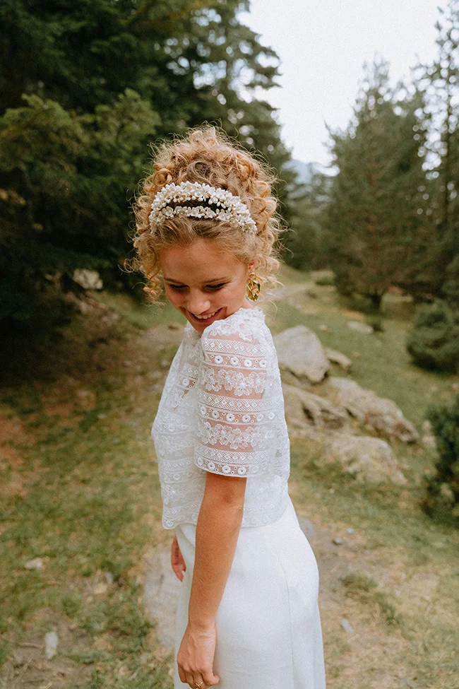 Une jeune mariée charmante dans son habillement blanc se promène dans un parc verdoyant, son sourire éclatant reflétant