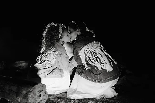 Un couple romantique partage un baiser tendre sous les étoiles, vêtus de vêtements traditionnels indiens dans les Pyrénées.