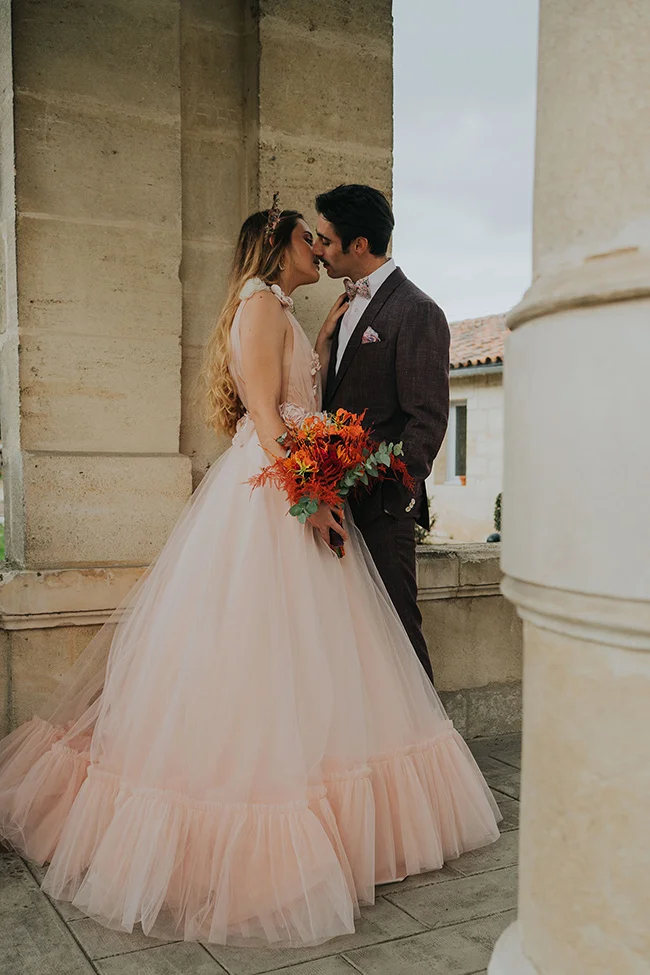 Un couple romantique se baigne dans une ambiance tendre et élégante, portant des vêtements de mariage subtils et