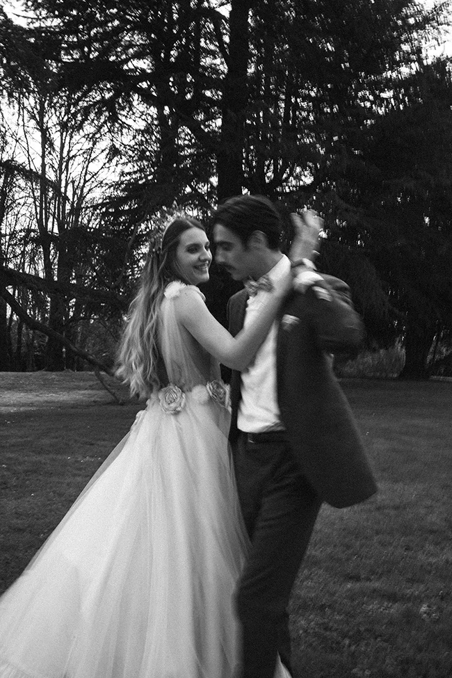 Un couple heureux dans des costumes de mariage classiques dans un parc romantique.