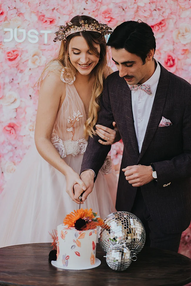 Un couple heureux partageant un moment romantique au moment du coup de couteau du gâteau de mariage, entouré d'ambiance
