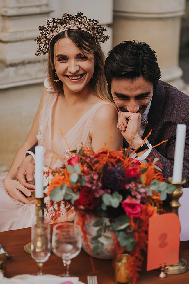 Un couple heureux partage un moment tendre au mariage pop love, entouré d'un bouquet vif de fleurs et de candela.
