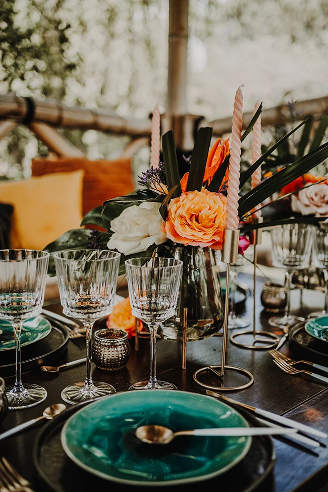 Table soignée avec des fleurs exotiques et des verres brillants, préparée pour un mariage glitters exotiques.