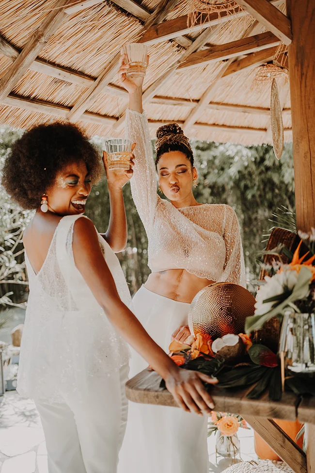 Célébration exotique avec des mariées en blanc et un décor en bois et en bambou.