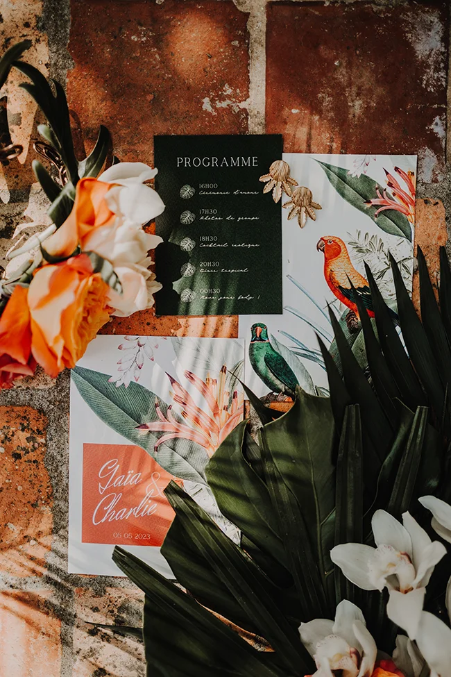 Un programme de mariage exotique avec des fleurs vibrantes et des oiseaux colorés.