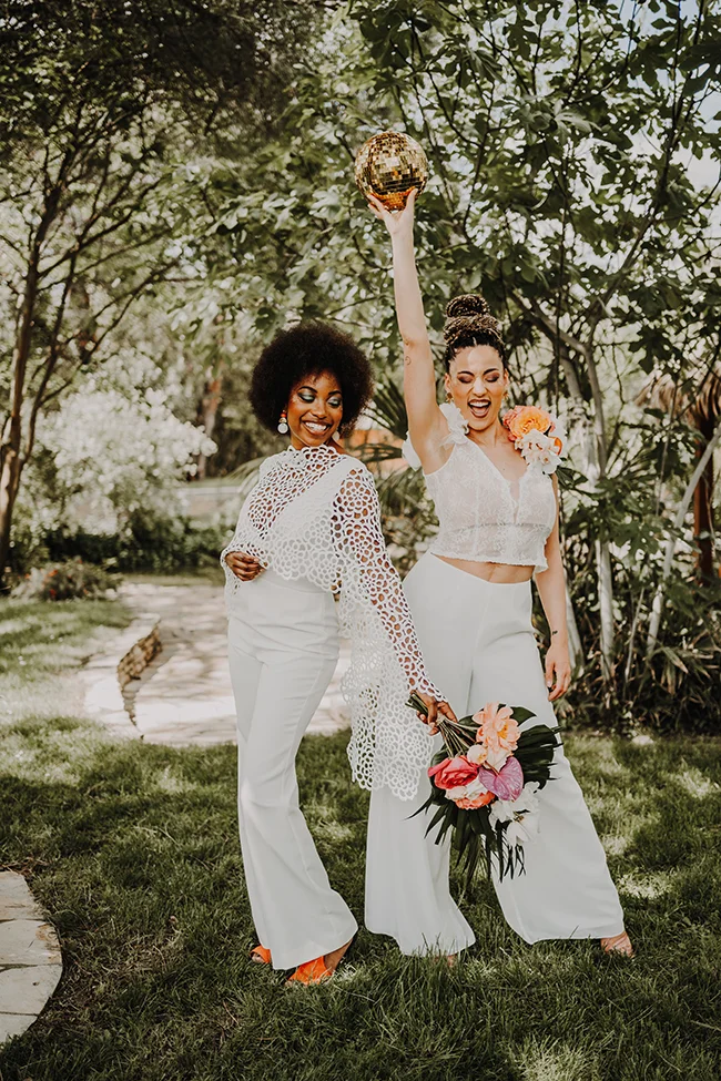 Joyeux couple dans des vêtements blancs, avec un miroir de disco, célébrant un mariage exotique et brillant.