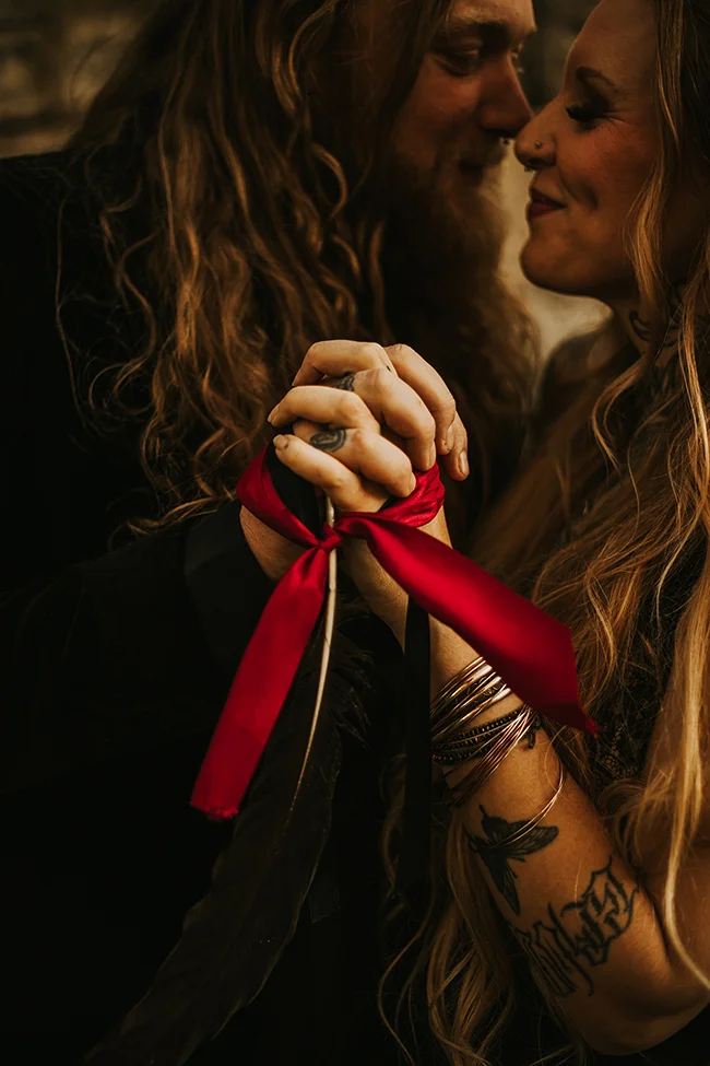 Un couple romantique partage un moment intime au sein d'un élopement sombre et élégant.