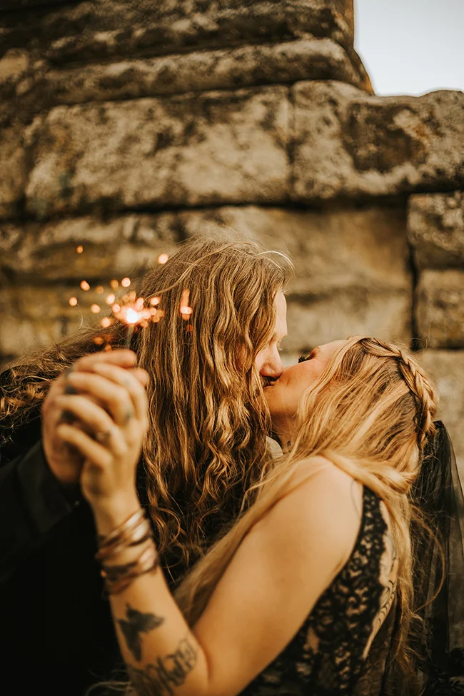 Un couple élopé partage un moment intime avec des feux d'artifice, incarnant l'élégance sombre et romantique d'un mariage secret.
