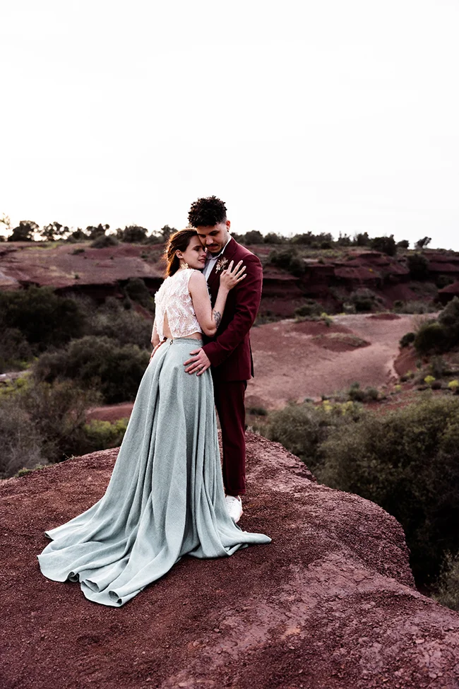 Un couple éloping romantique sur un falaise au Canyon du Diable, habillés dans des vêtements bohémien chic.