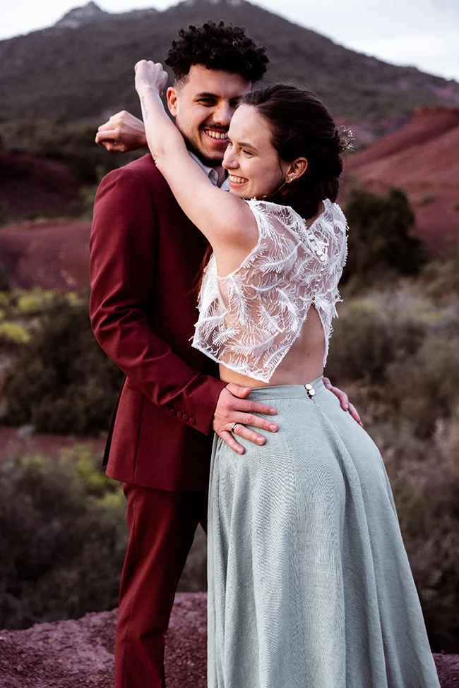 Un couple heureux dans des vêtements bohèmes chic contre un fond naturel époustouflant.