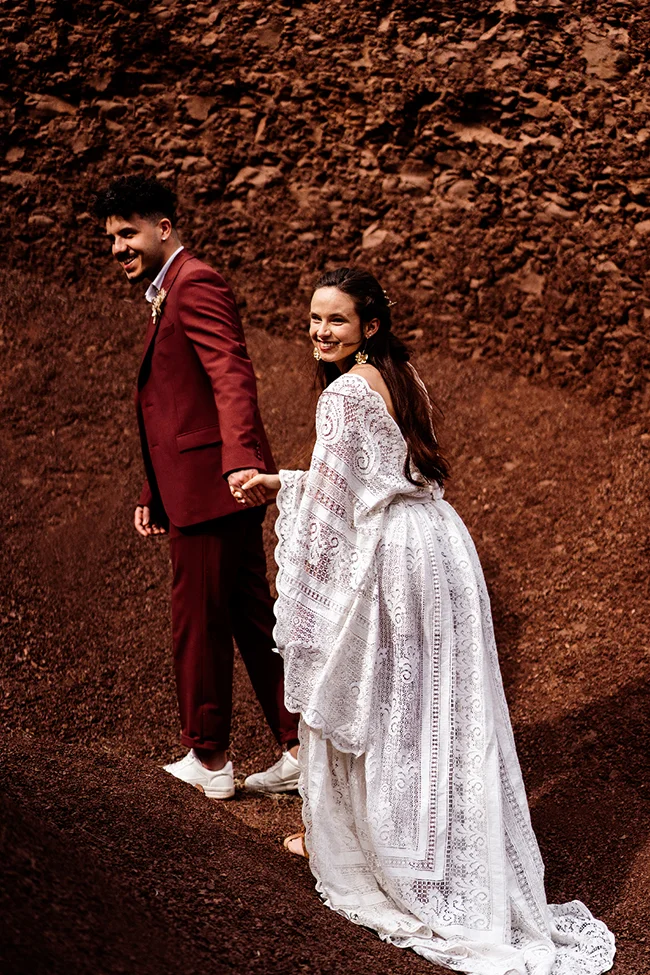 Magique scène d'élopement bohémien au Canyon du Diable, avec un couple émerveillé dans des vêtements romantiques.