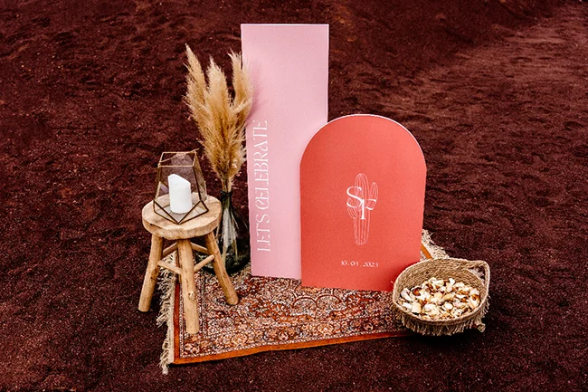 Élopement bohème au Canyon du Diable, décor avec panneaux rose, cactus et chapeau de paille.