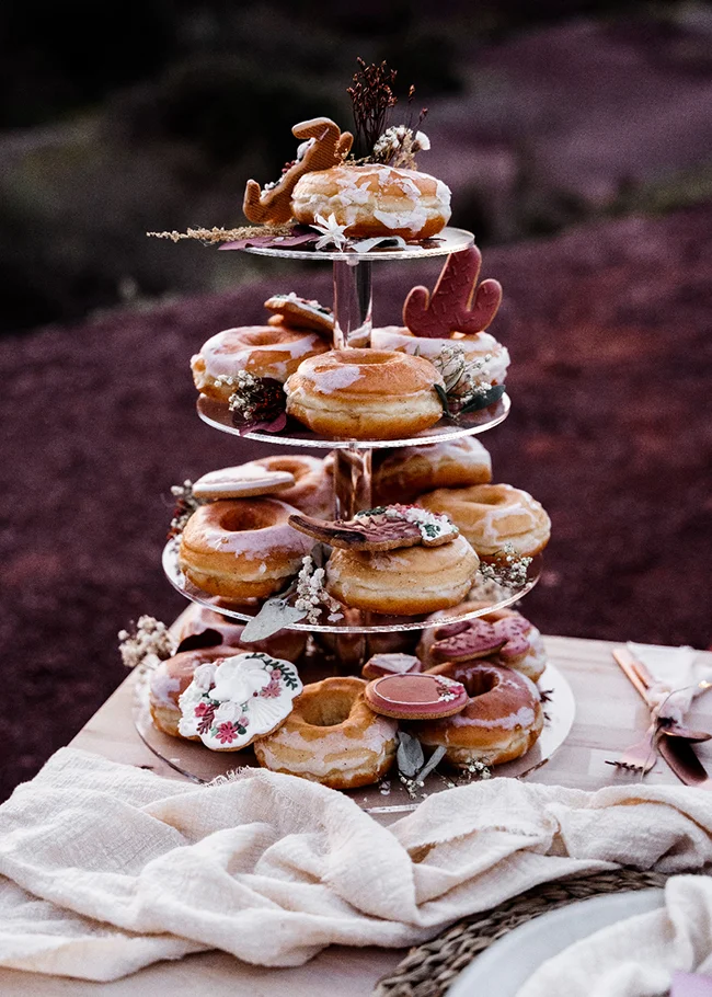 Tableau délicieux de donuts décorés avec une touche bohème au cœur d'un élopement hippie chic dans le Canyon du Diable.