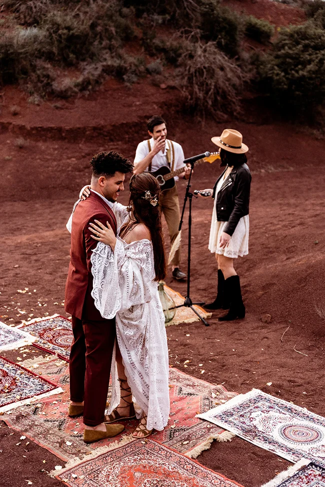 Un couple élopé se marie dans un décor bohémien au Canyon du Diable, avec des tapis persans colorés et une musique
