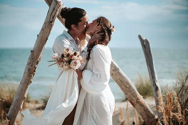 Un couple romantique se marient sur la plage en Camargue, leur amour éclatant dans un décor paisible et serein.