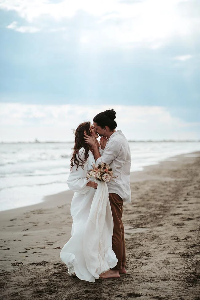 Un couple romantique se baigne dans l'ambiance paisible de la plage de Camargue, célébrant leur amour avec un elopement intime.