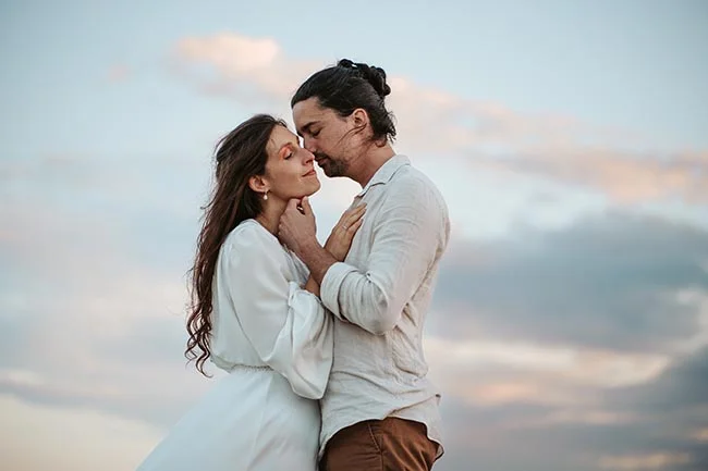 Un couple romantique partage un moment tendre sur la plage de la Camargue pendant un élopement intime.