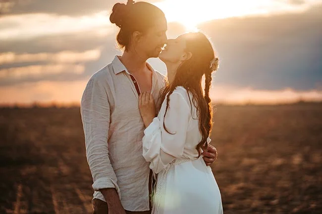 Un couple romantique se baigne dans la lumière du coucher de soleil sur la plage de la Camargue.