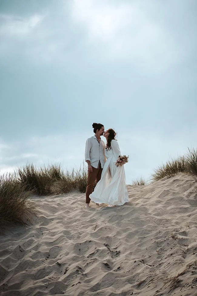 Un couple romantique se baigne dans l'ambiance paisible de la plage de la Camargue, célébrant leur amour avec grâce et simplicité.