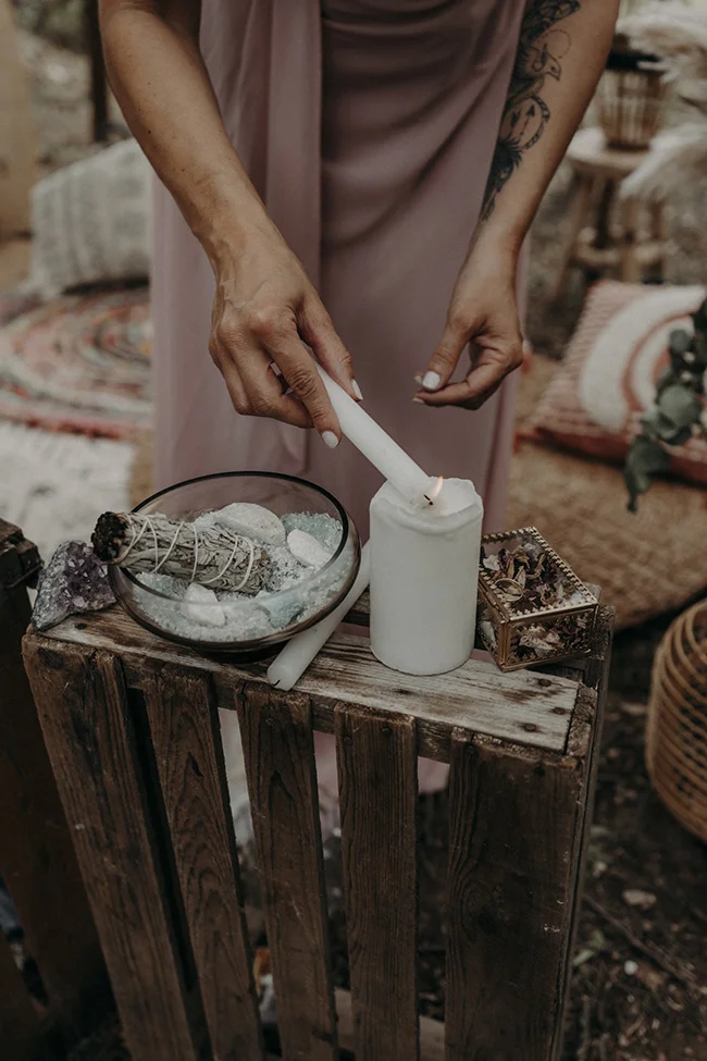 Une main tendue avec un bâton de cire, allant au fond d'un décor romantique et paisible.