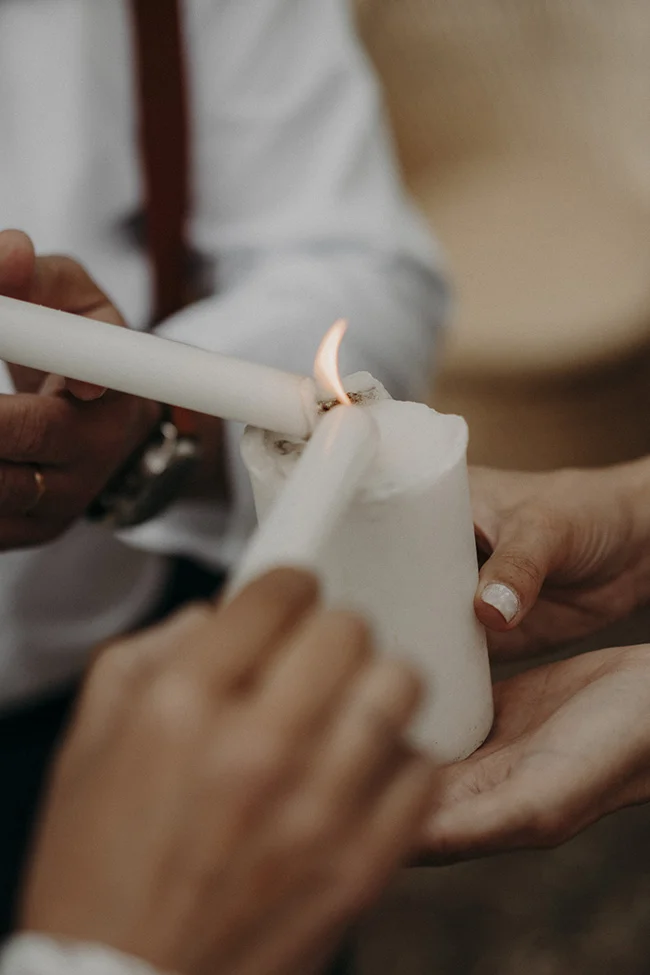 Un couple délivre un moment tendre, allant au feu d'un candle blanc, symbolisant l'union et la chaleur d'une nouvelle