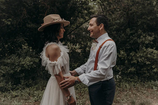 Un couple heureux dans des vêtements bohémien, célébrant leur mariage dans une forêt paisible.