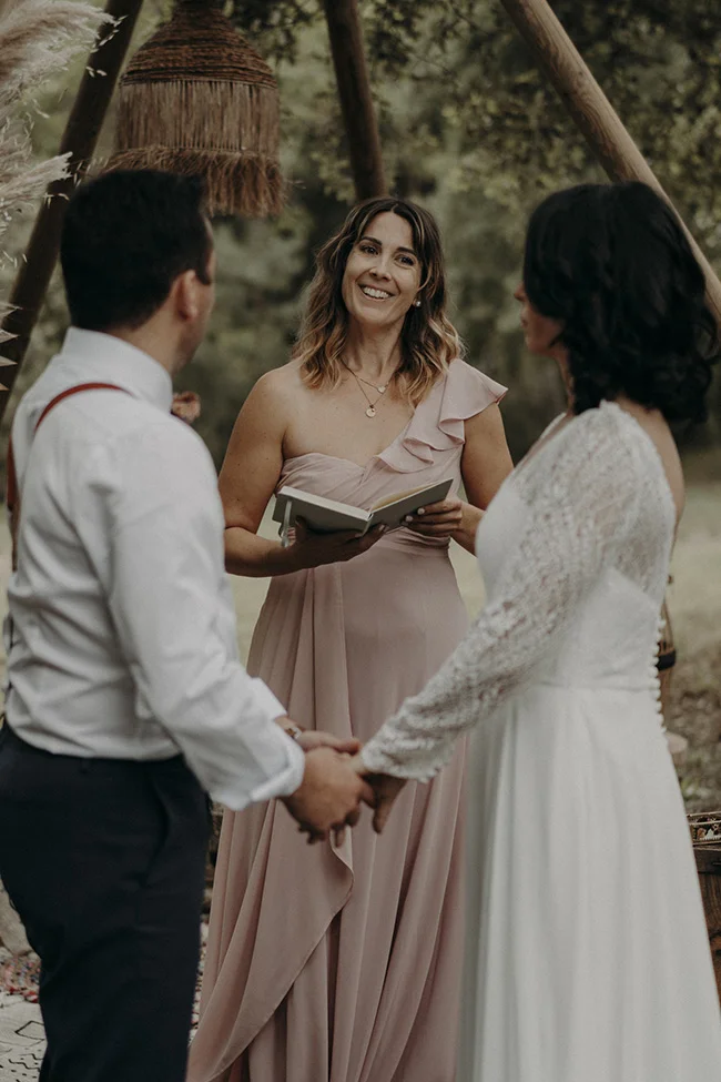 Un couple se tient tendrement les mains, entouré d'ambiance paisible et décorations naturelles dans un mariage Boho à Uzès.