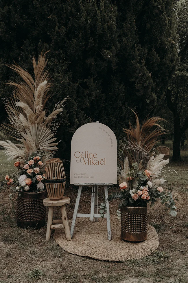 Un décor romantique pour un mariage bohème à Uzès, avec un panneau blanc marquant l'union de Céline et Mikael.