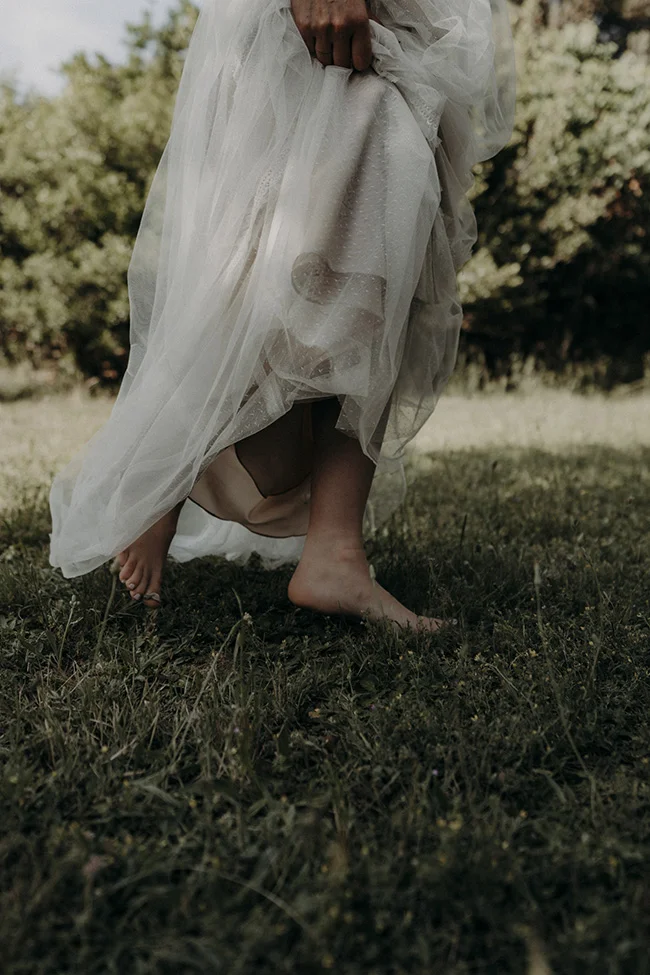 Un pied nu dans l'herbe, un robe bohème légère, un instant romantique dans un mariage à Uzès.