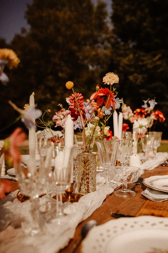 Un banquet intime avec des fleurs colorées et des verres clairs.