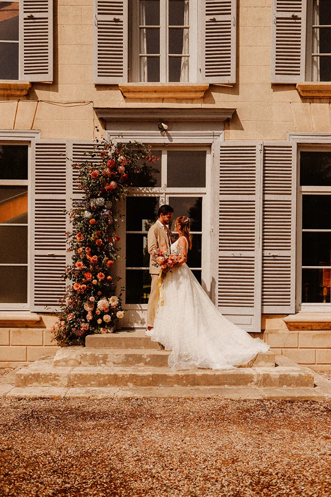 Un couple de mariés charmants se baignant dans l'ambiance romantique d'un décor intime et coloré.