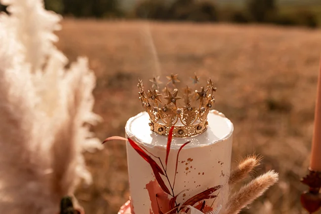 Un gâteau de mariage magnifique avec une couronne d'or, symbolisant l'élégance et la royauté.