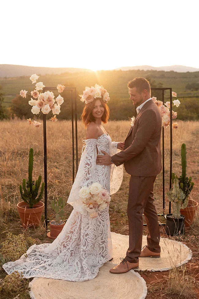 Un couple heureux se prépare pour le mariage dans un décor romantique au coucher de soleil.