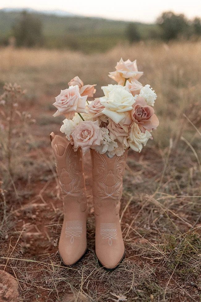 Bottes de cowboy romantiques avec une floraison douce, idéaux pour un mariage fun et spirituel avec une touche mexicaine.