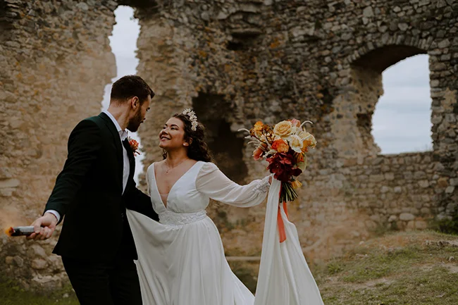 Une mariée et un mari savourant un moment romantique dans les ruines d'un château historique.